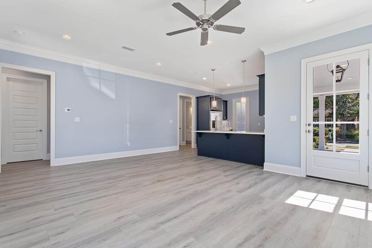 结合客厅和厨房，浅蓝色的墙壁和硬木地板。