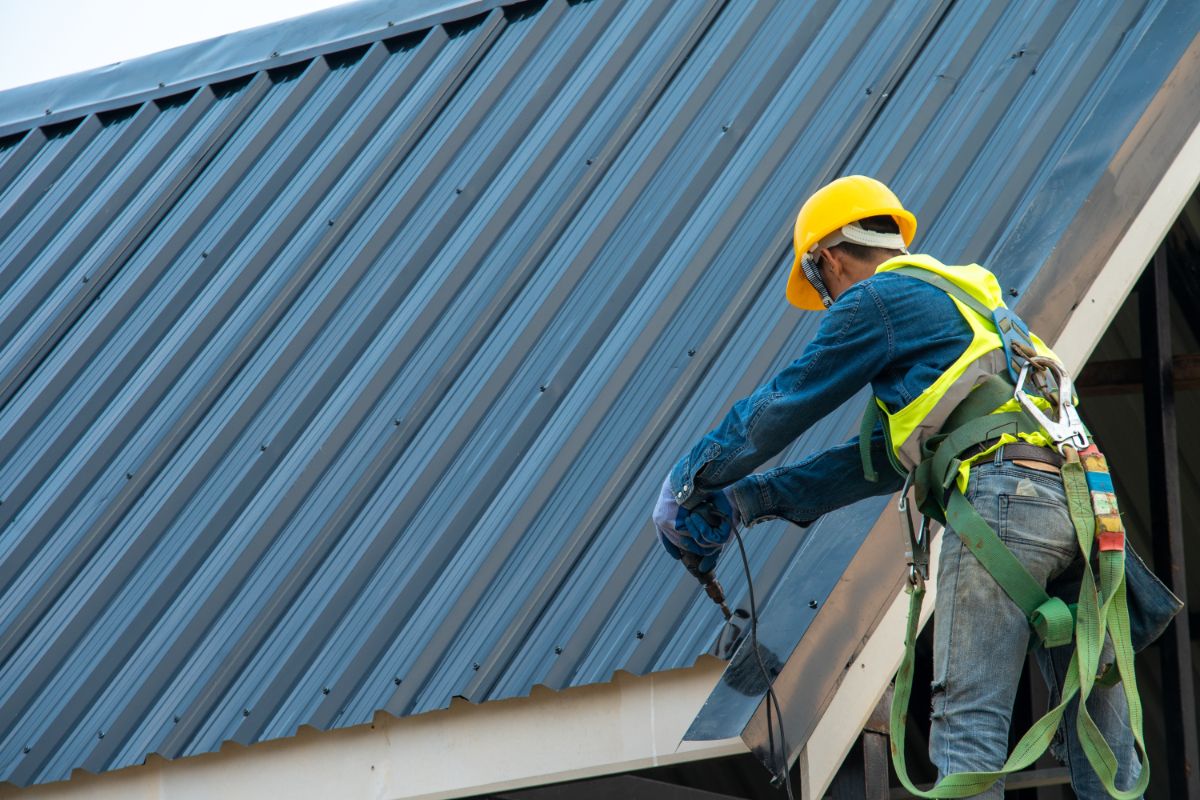 一名男子正在安装金属屋顶。