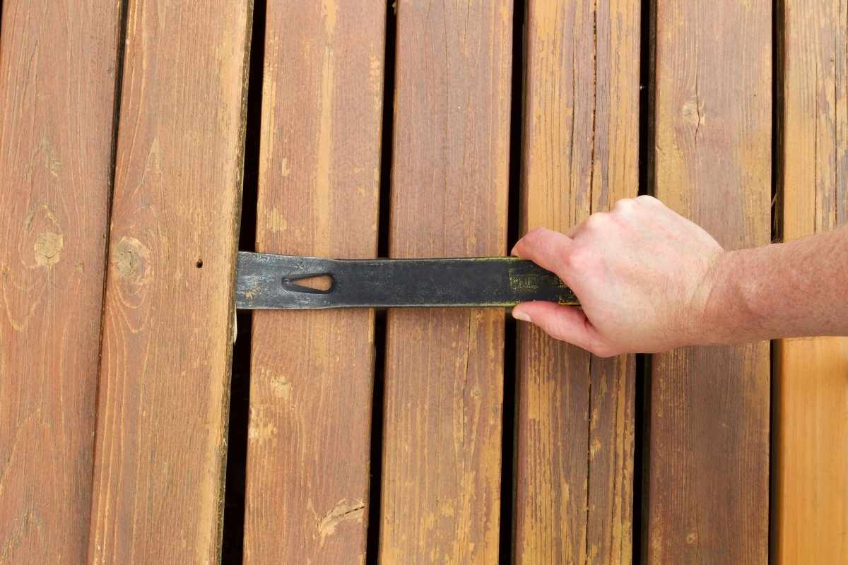 使用撬杆拆卸旧木板。
