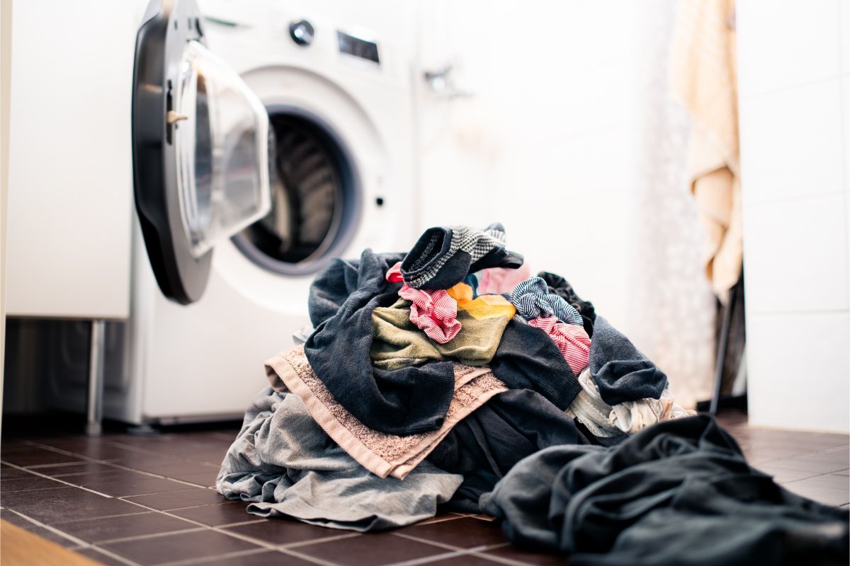 一堆准备在洗衣机里洗的旧衣服、内衣和毛巾。