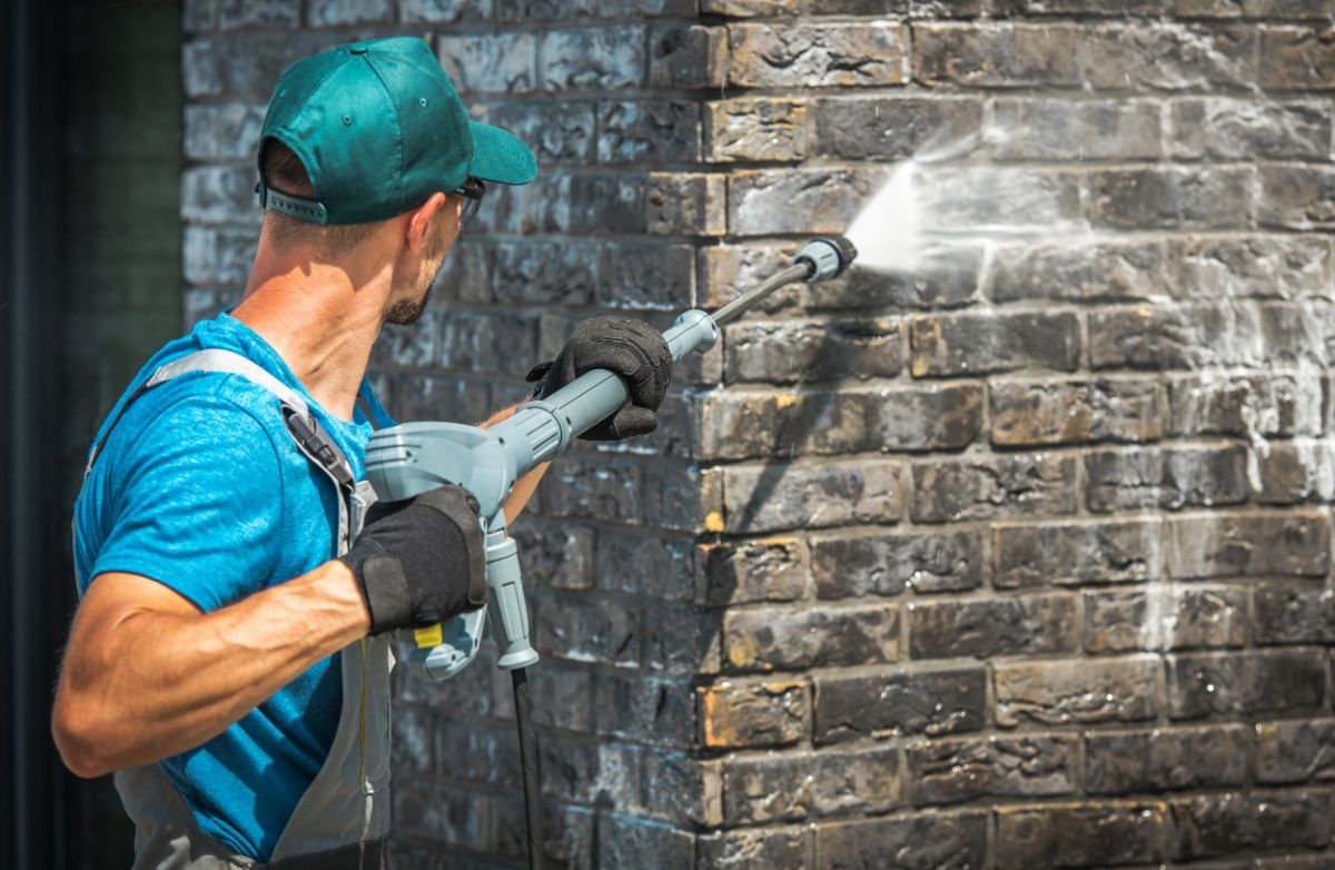 一个男人正在清理混凝土砖墙。