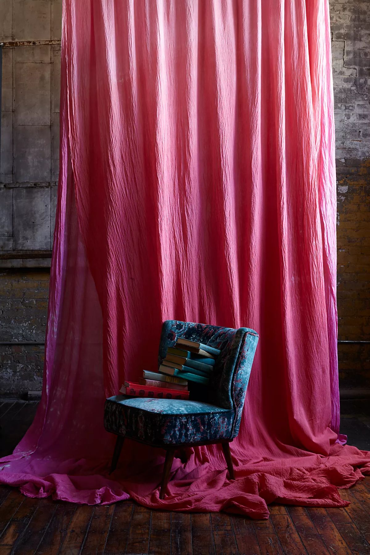 由Anthroliving制作的粉红色窗帘前面是华丽的丝绸口音椅