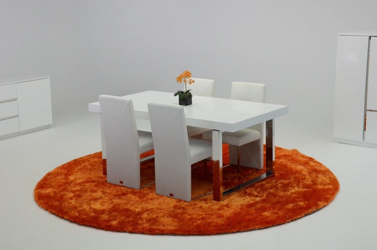由Vig家具制作的橙色地毯上的白色餐桌令人惊叹