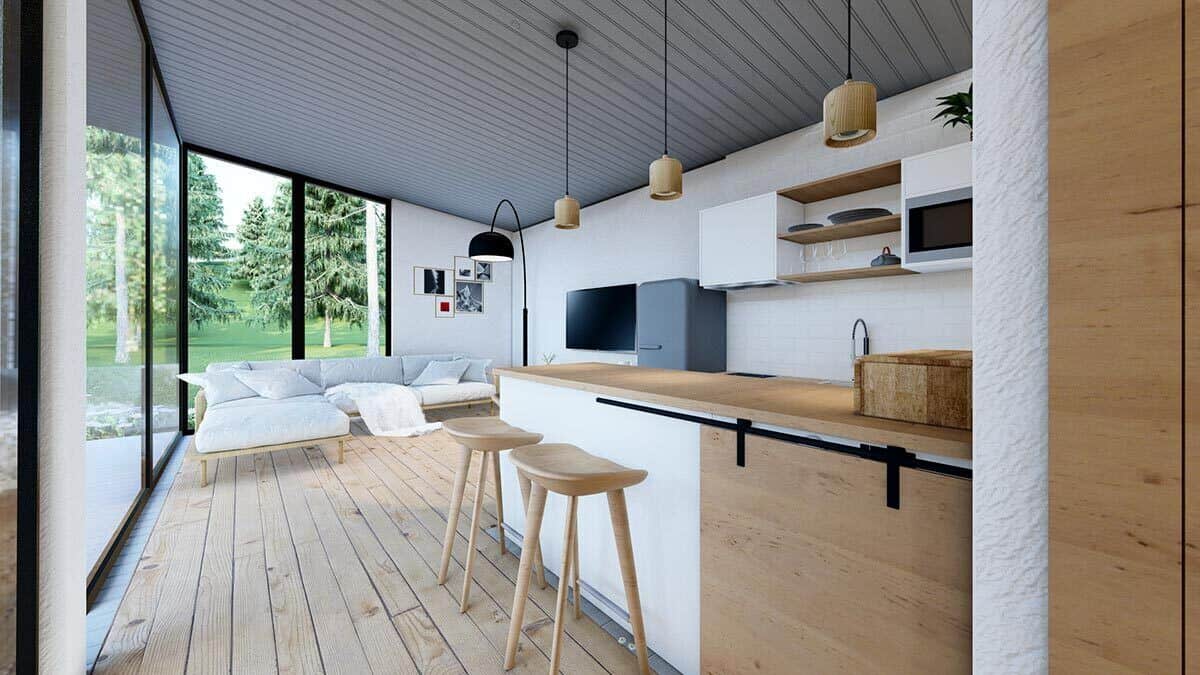 客厅和厨房结合了宽木板地板，棚子镶板天花板，落地窗使该区域充满自然光。