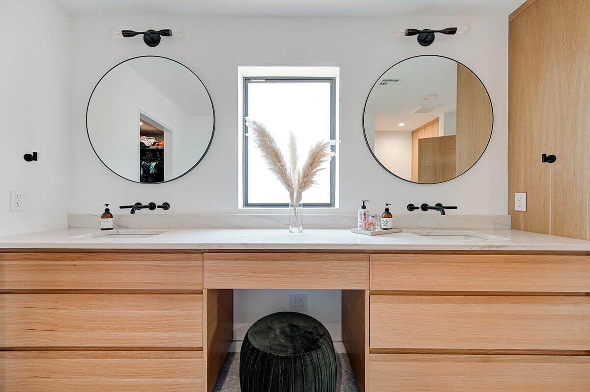 主浴室有一个很大的木质虚荣配备了他和她的下沉,两个圆镜子,化妆柜台在中间。