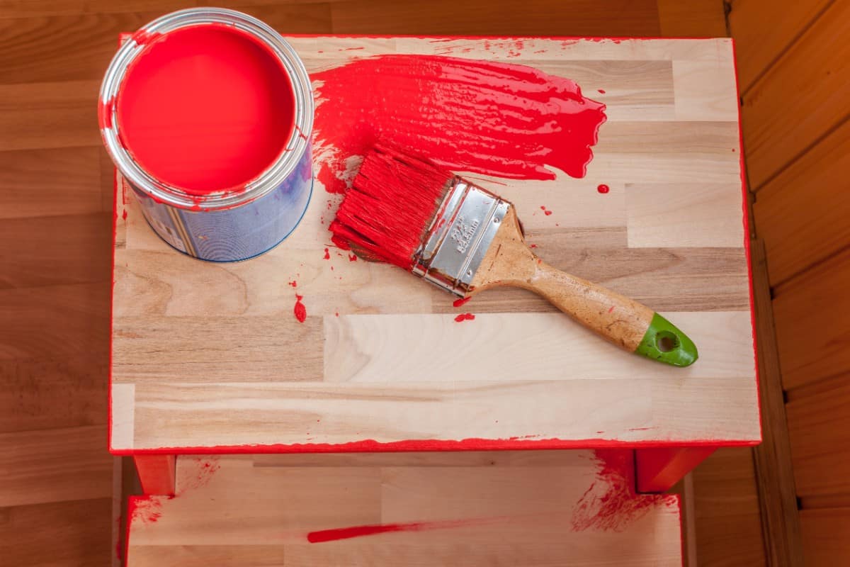 木椅上的红色油漆和刷子。