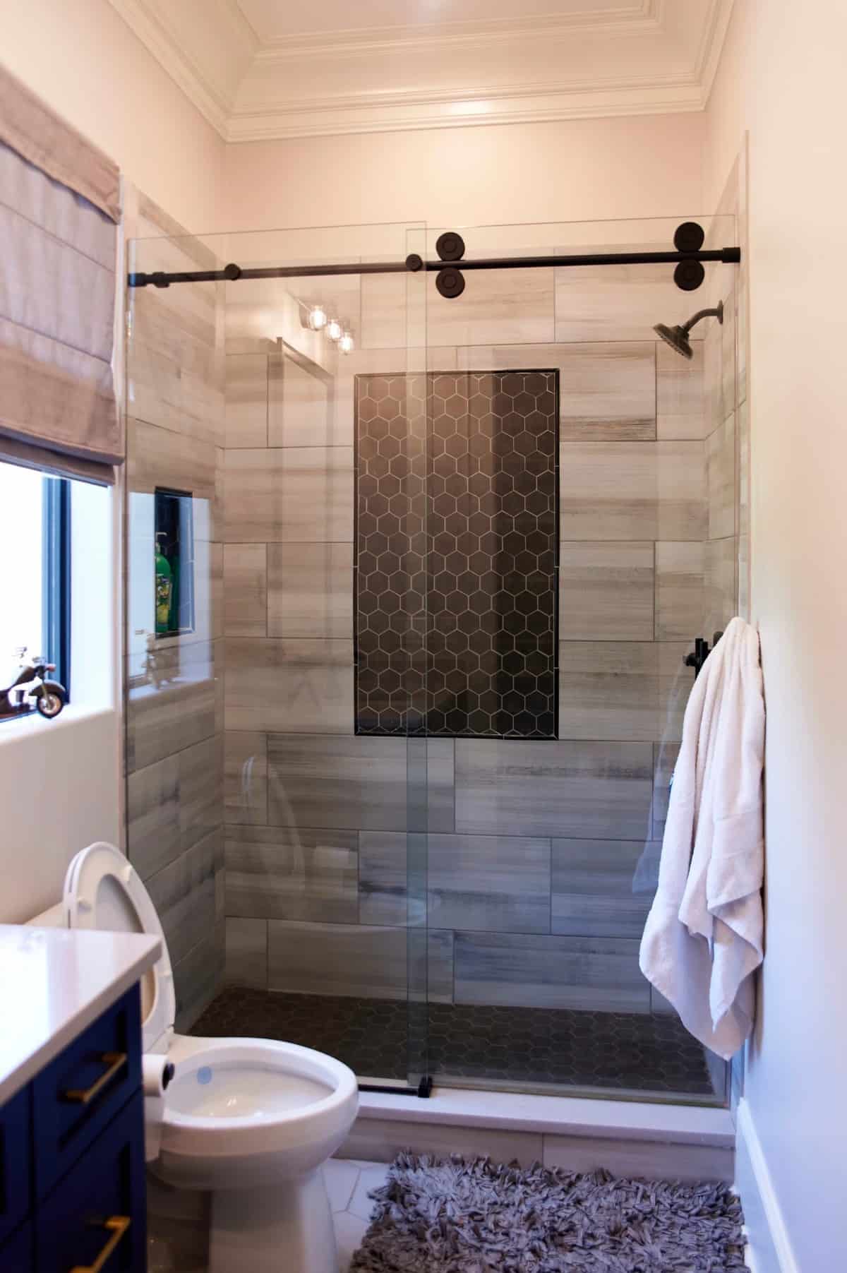 这间浴室配有洗手台、马桶和一个用滑动玻璃门封闭的步入式淋浴间。