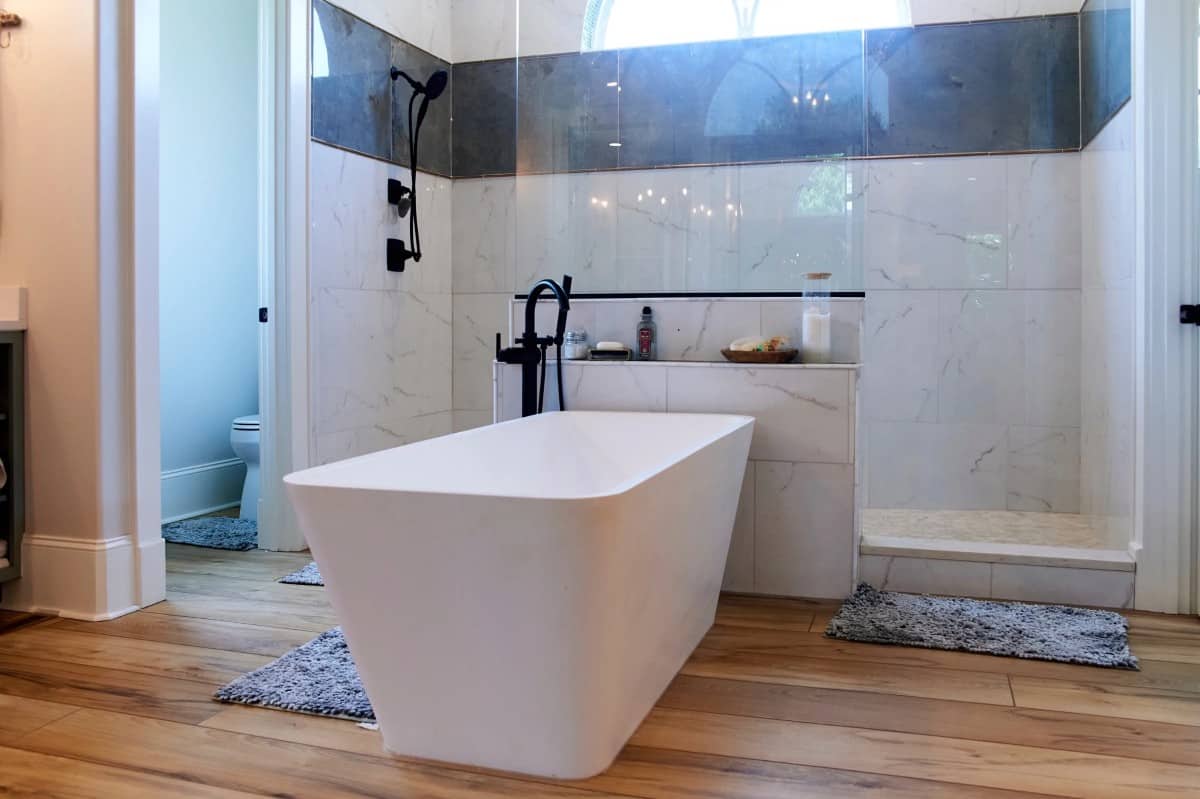 主浴室设有独立浴缸和宽敞的步入式淋浴间，带有两扇玻璃门。