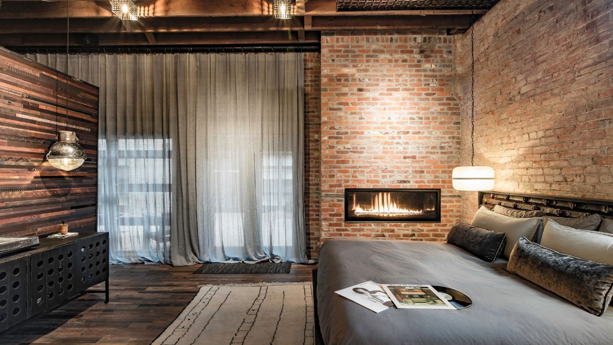 主卧室里令人惊叹的胡桃木悬空床就在吊灯和架子对面，壁炉旁边。