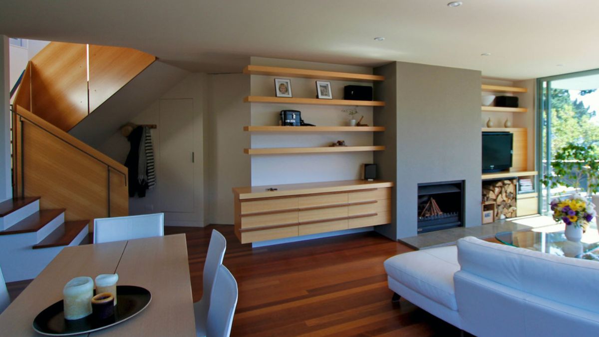 室内客厅的展示一个共享空间,餐饮和生活,有一个壁炉和家具,补充了房子的建筑设计。