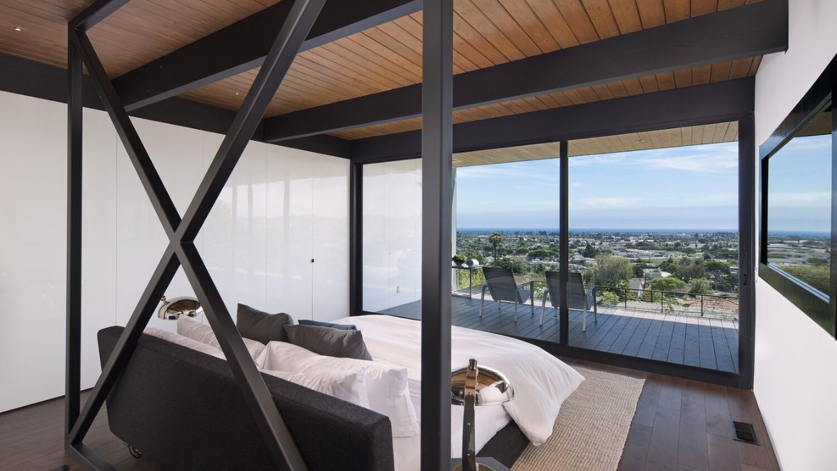 卧室里提供了一个详细视图的设计和功能,包括能够在周围景观的惊人的观点通过使用全高度玻璃窗户。