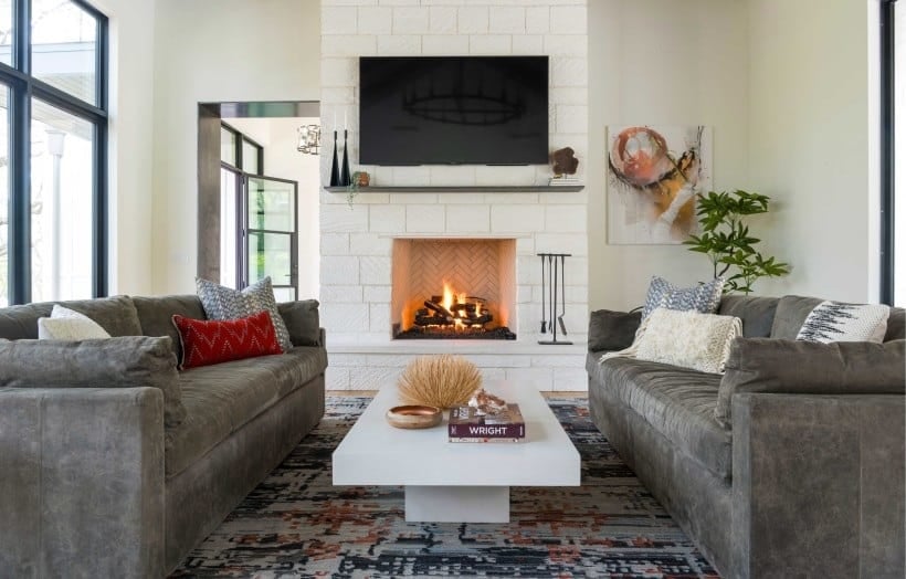 电视上的石壁炉是反映在客厅。它包括面临天鹅绒沙发和现代的咖啡桌。