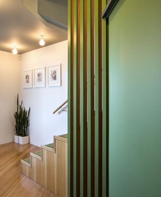 一张照片有一个侧楼梯角展示木和绿色色调的和谐融合框架艺术品装饰墙上。