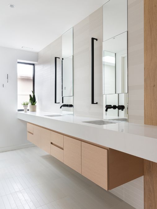 浴室的详细视图，展示了两个洗手台，下面悬挂着棕色橱柜，提供了充足的存储空间。