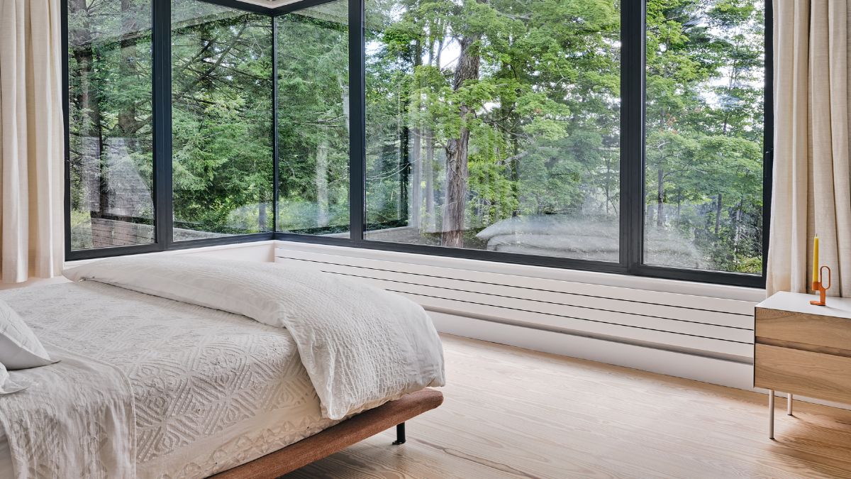 在本地获得宽板装饰卧室的地板上,加强自然环境透过落地角落窗口。