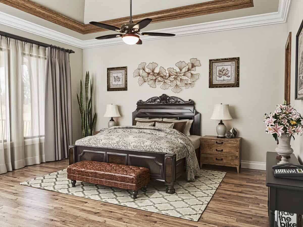 主卧室里有暗木家具，铺着硬木地板，上面铺着带图案的区域地毯。