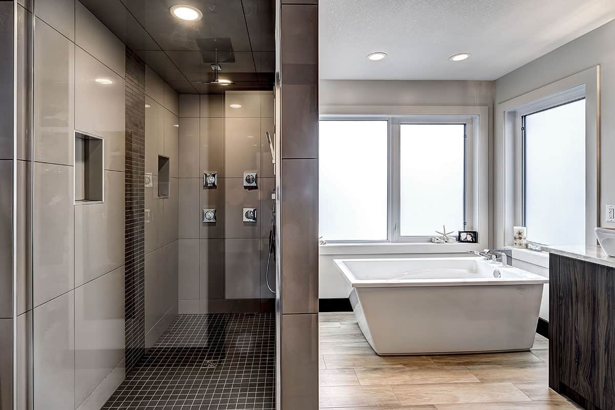 主浴室里有一间步入式淋浴间和一间独立浴缸，浴缸内的滑动窗使光线更加明亮。
