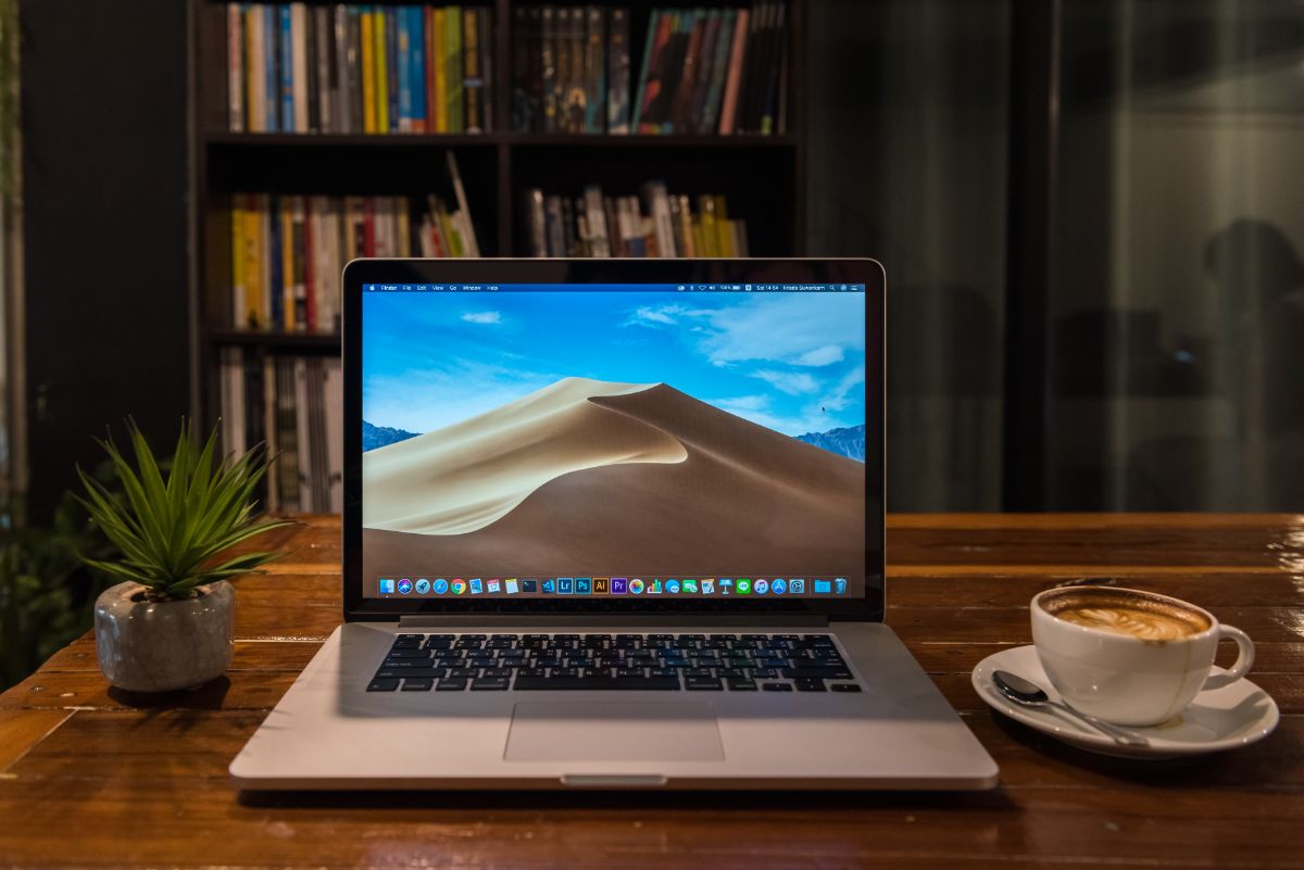桌上放着一台MacBook pro和一杯咖啡。