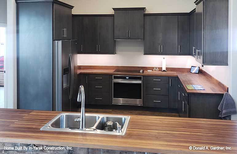 厨房包括黑色橱柜、木制台面,不锈钢电器。