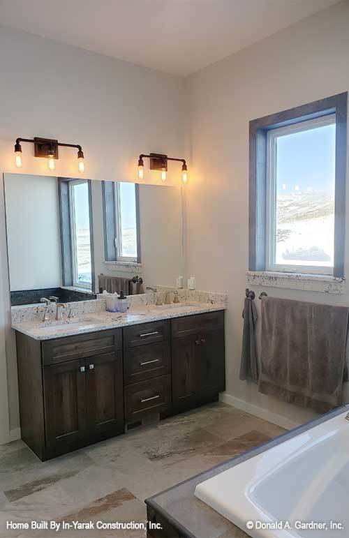 主浴室有一个双水槽顶部设有一个无框架镜虚荣和温暖的头上。
