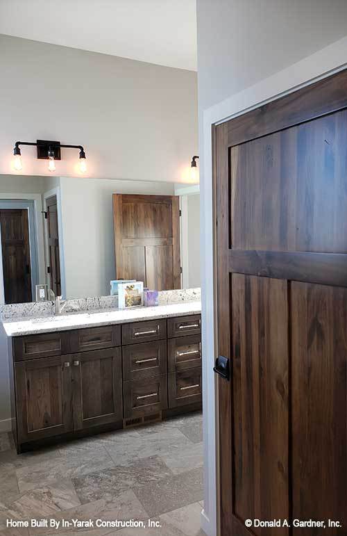 这个浴室暗木梳妆台配备两个洗手池,无框架镜,铁艺烛台。