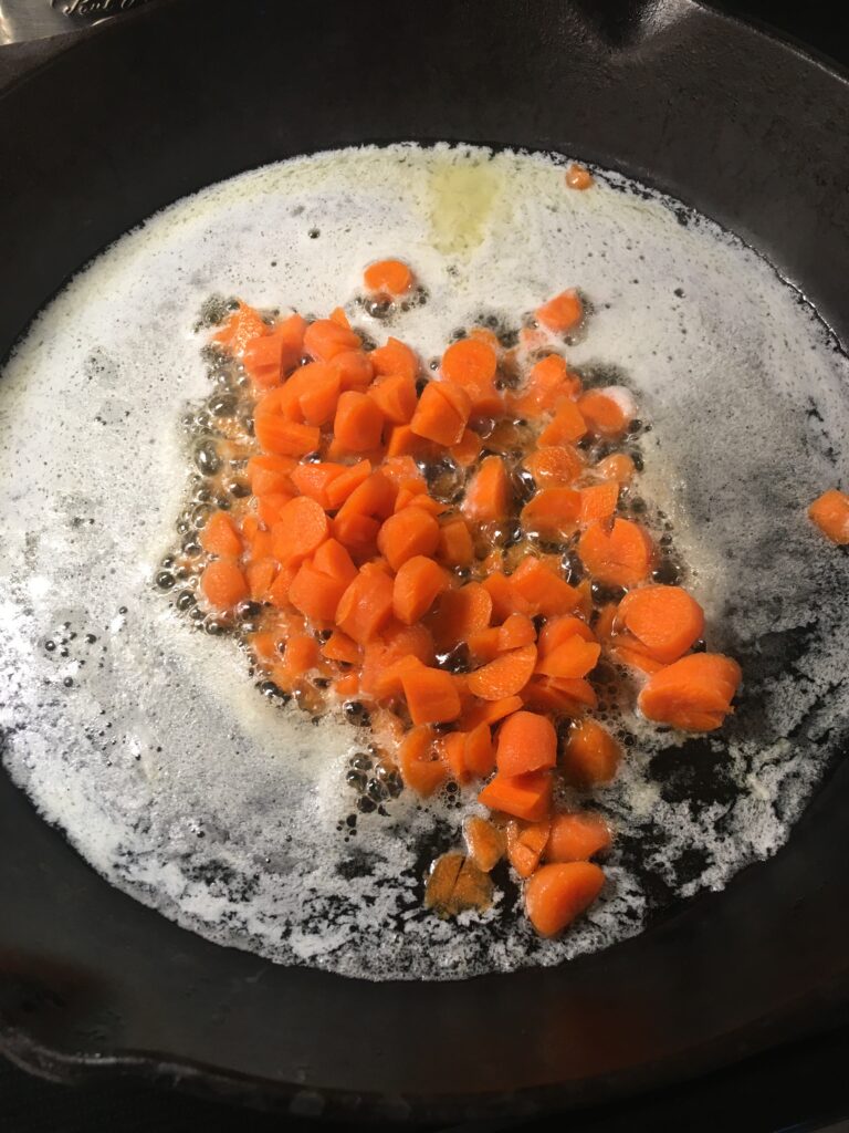 将切碎的胡萝卜加入融化的黄油中。