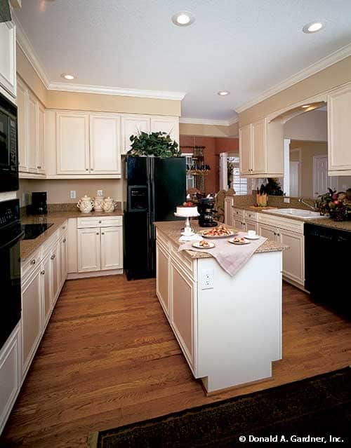 厨房配备了黑色电器、对比鲜明的橱柜、花岗岩台面和一个中央岛台。