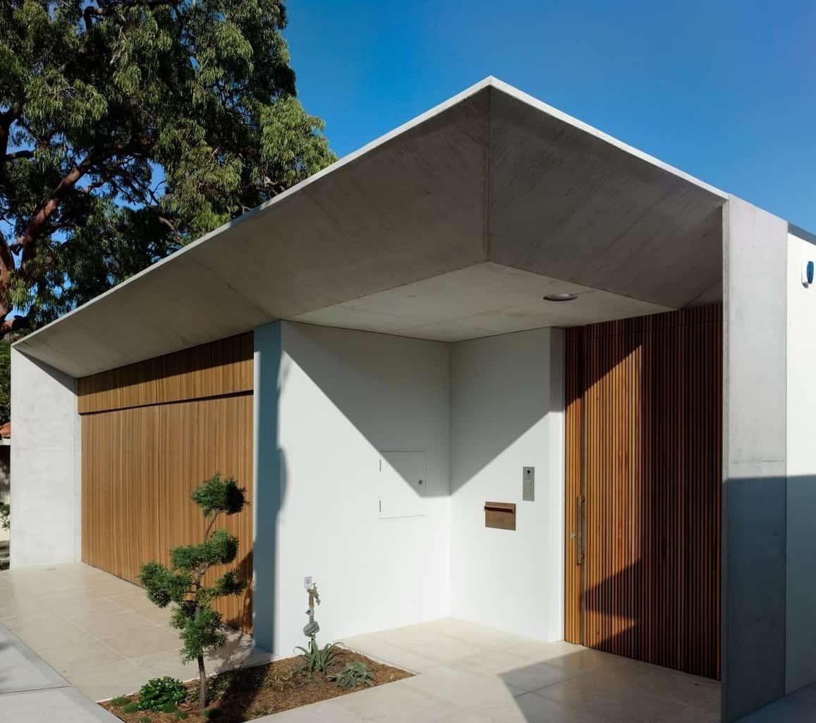 住宅façade的角度视图展示了干净的线条和白色的外观，与木材的口音形成对比。