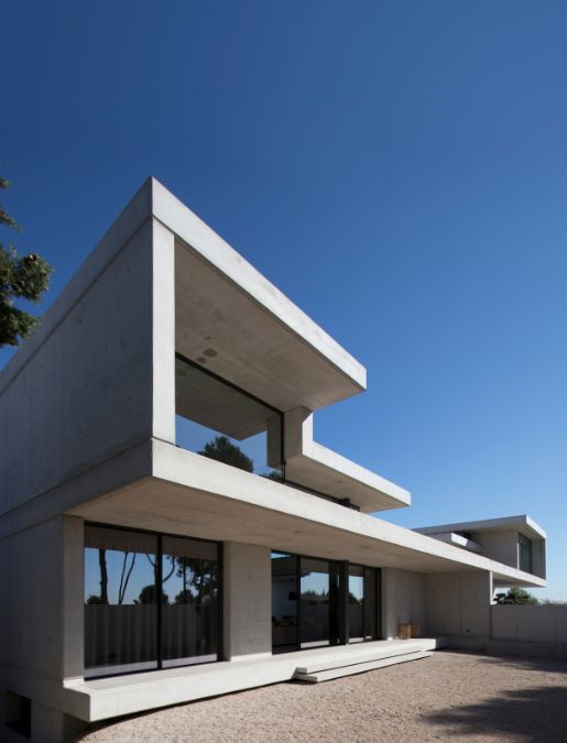 一个低角度的镜头强调了房子的当代混凝土建筑设计。
