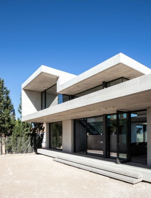 一个低角度的镜头强调了房子的当代混凝土建筑设计。