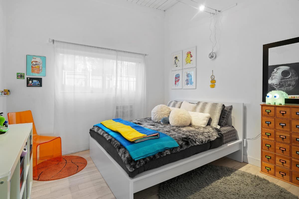 这间卧室的特色是一张橙色的幽灵椅和一张白色的床，与原始的墙壁融为一体。