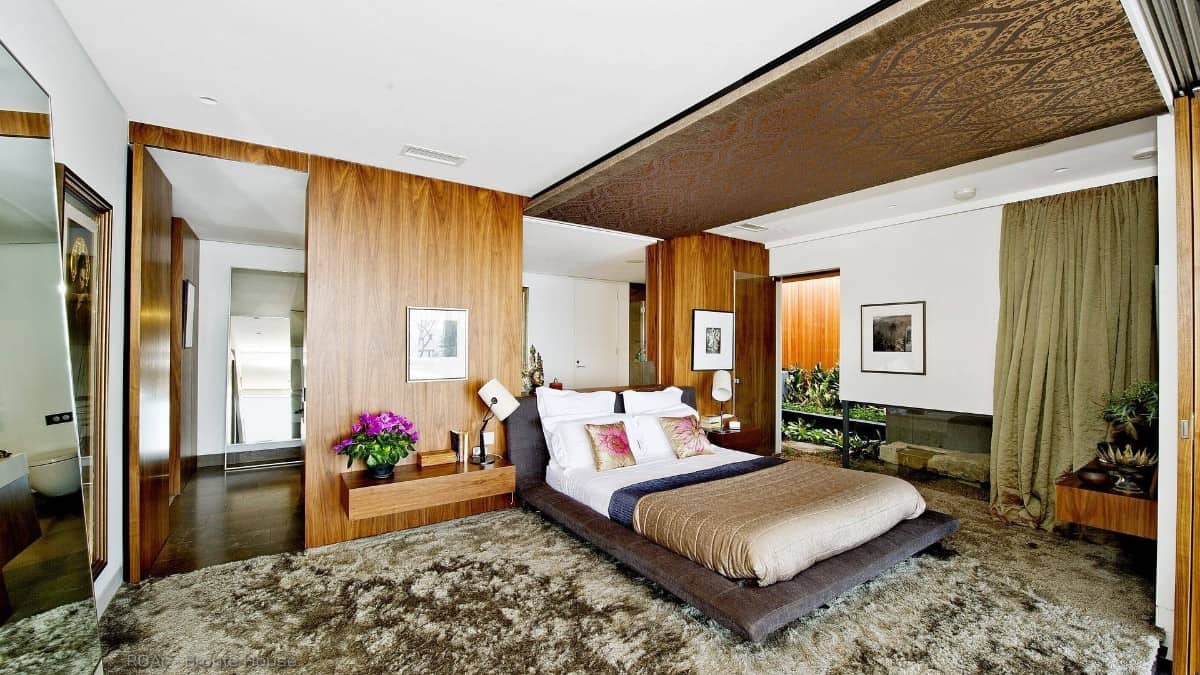 主卧室里有一张台地床和一面装有浮动床头柜的木板墙。