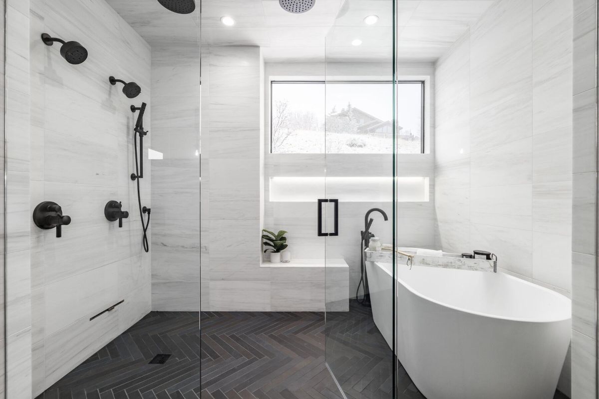 白色浴室设有淋浴房和独立式浴缸。