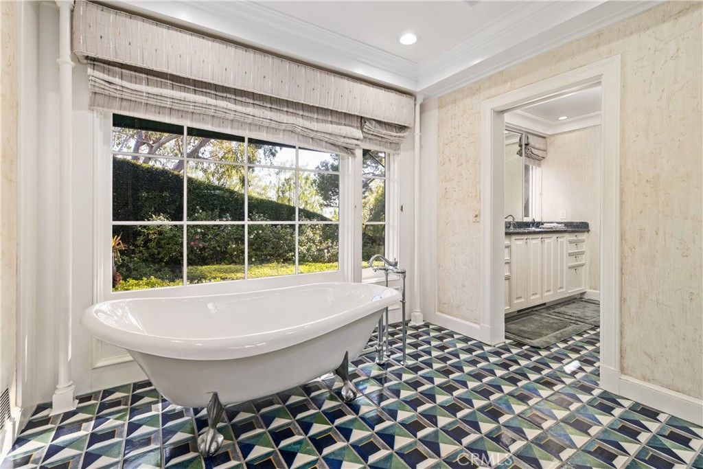 浴室有一个独立的浴缸和玻璃窗展示环境。