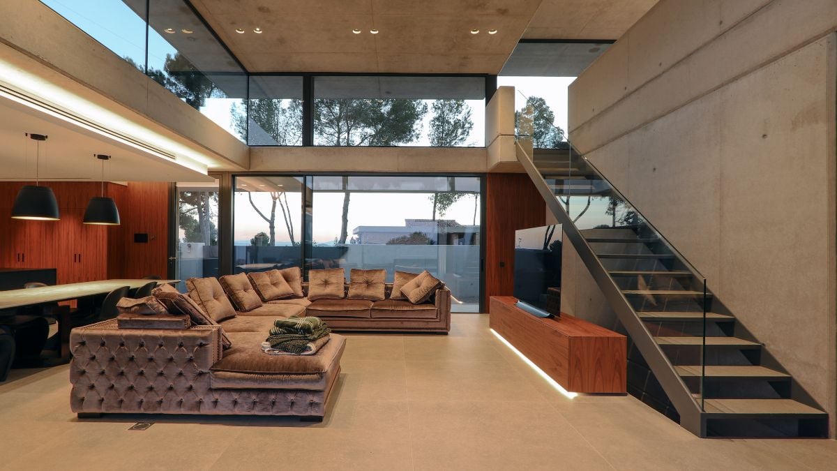 一张室内照片捕捉到了生活空间的复杂设计，以玻璃板为边界，并在一侧设置了引人注目的楼梯。