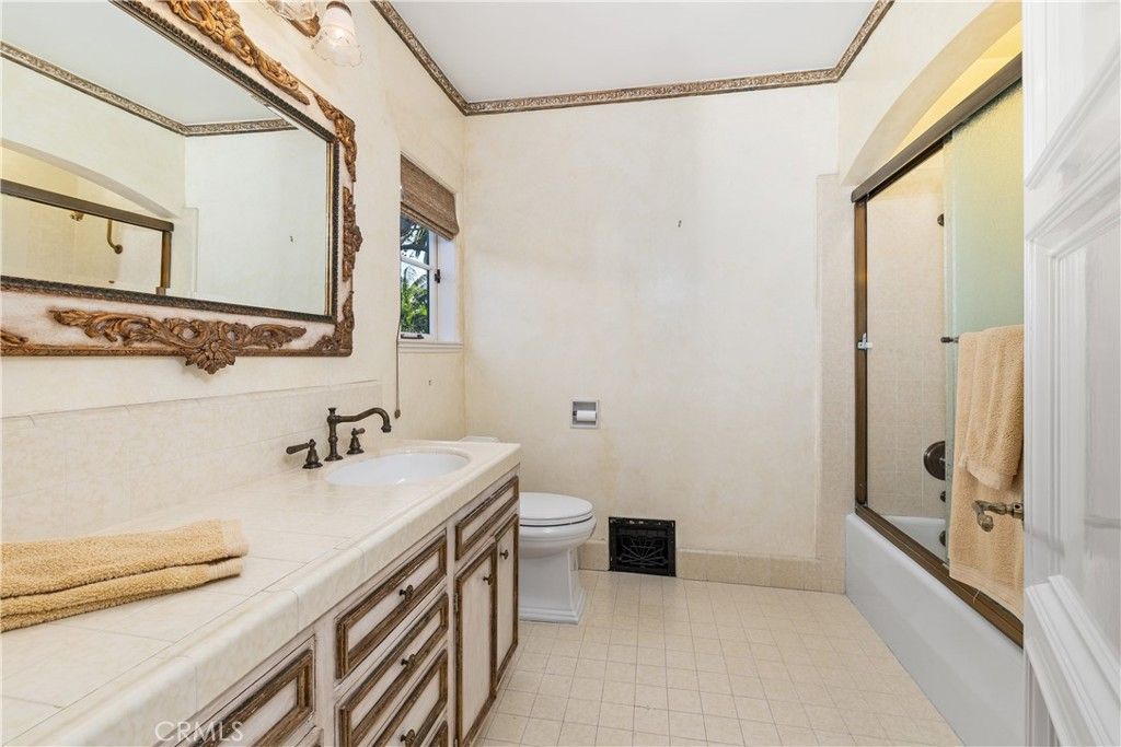 浴室有一个虚荣心瓷砖灶台,抽屉里有一个木制的轮廓给房间豪华的感觉。