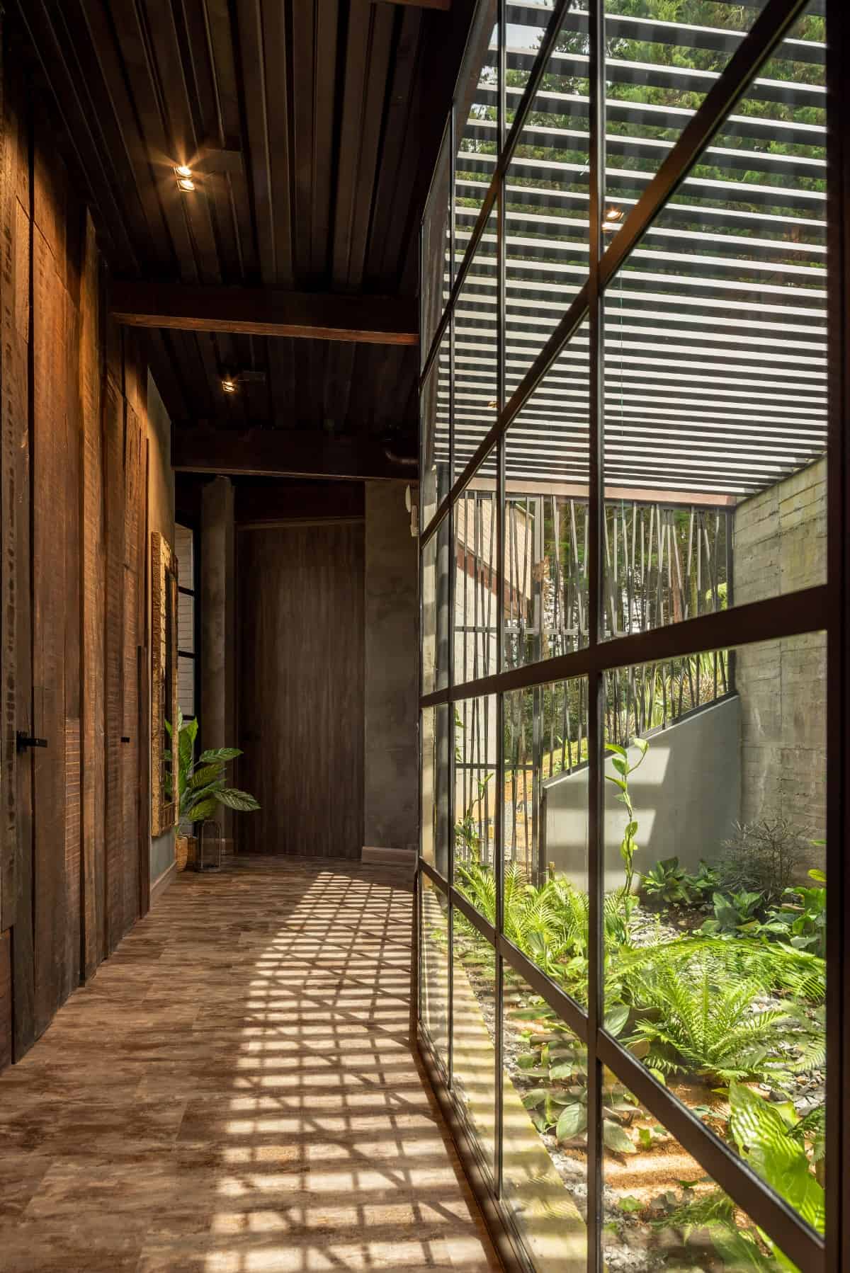 走廊两侧有木板墙和落地窗，可以俯瞰花园。