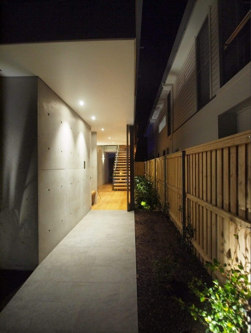 木质栅栏和绿色植物为住宅的入口提供了隐私。