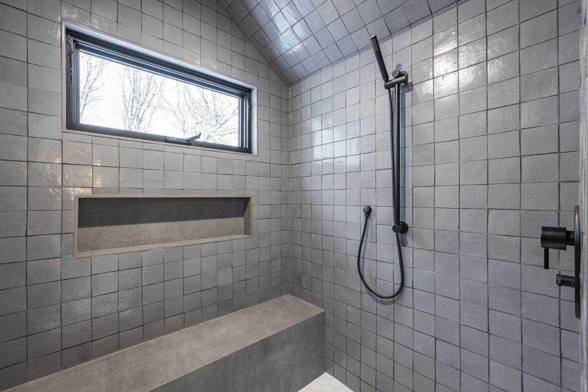淋浴房设有混凝土浴室长凳和瓷砖墙。