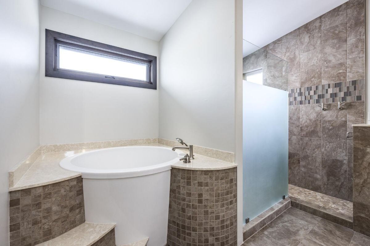 浴室设有一个圆形浴缸和一间带磨砂玻璃的淋浴间。