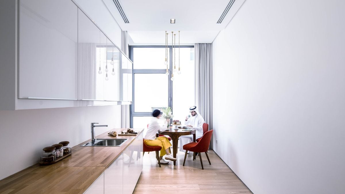 白色粉刷的厨房，棕色的台面在一个狭窄的空间里。