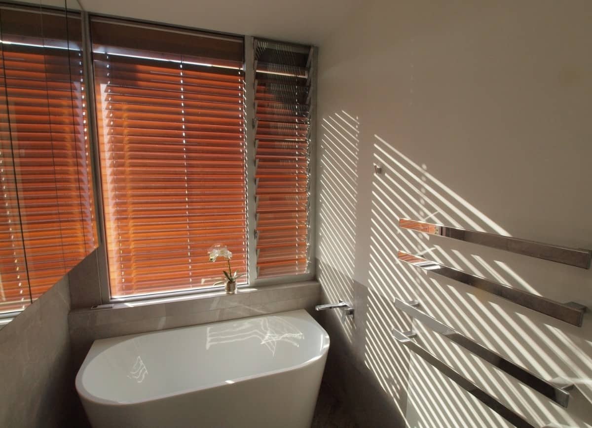 自然光透过百叶窗射入浴室。