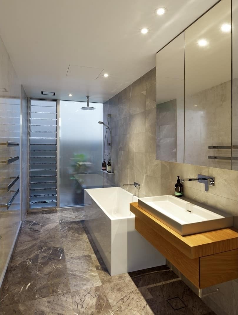 这间浴室有一个光滑的独立式浴缸和一个带大水槽的浮动梳妆台。