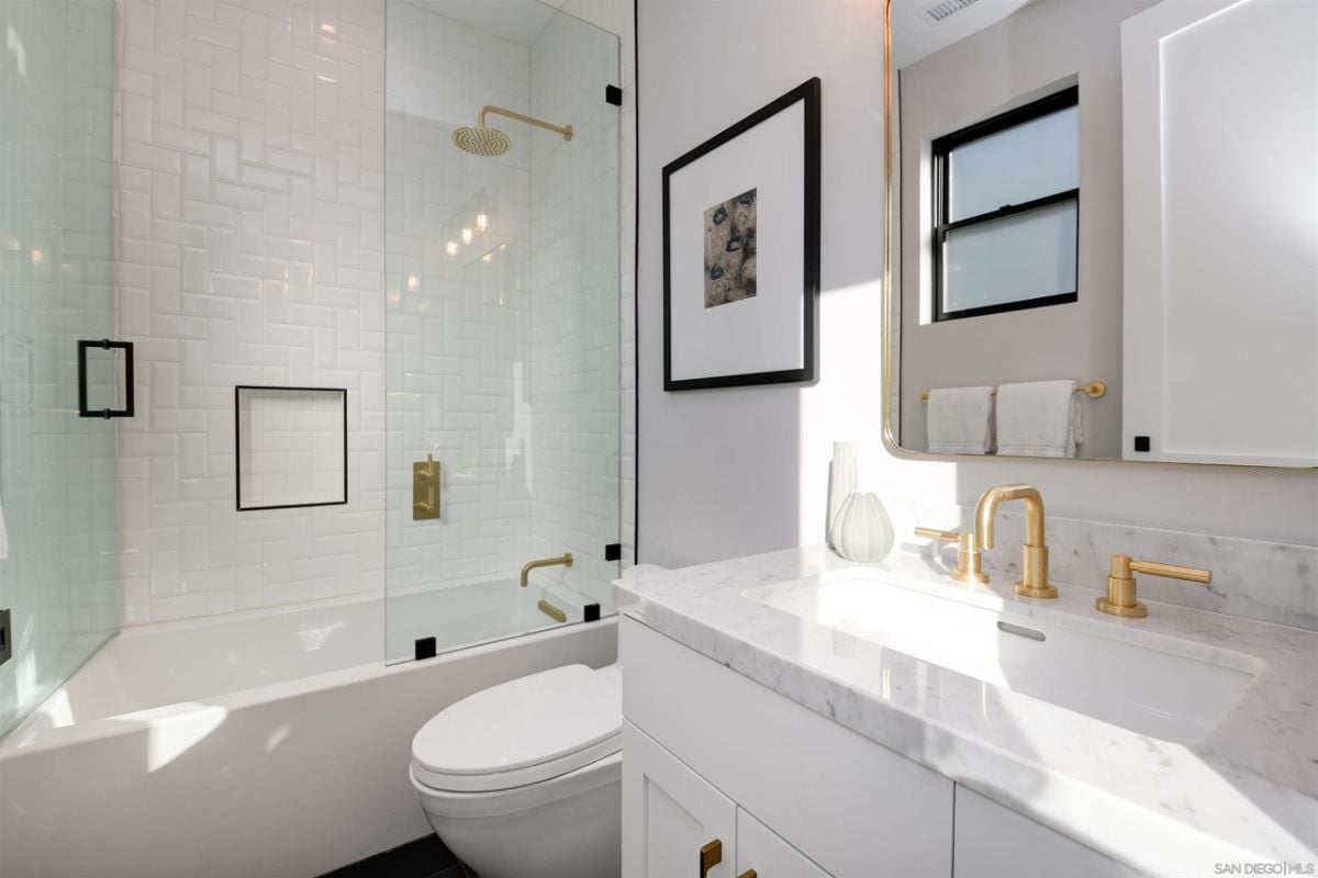 浴室有一个内置的浴缸和虚荣与瓷砖台面。