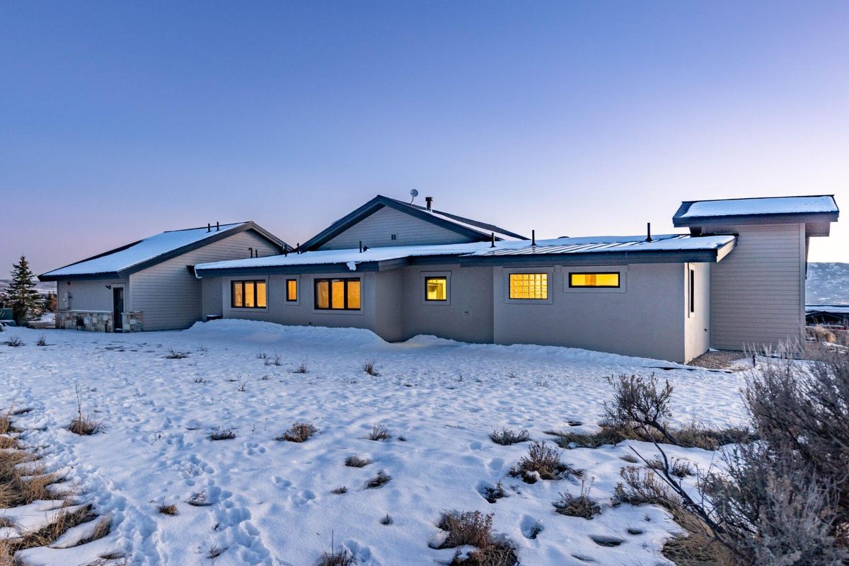 房子的后院覆盖着雪，灯光在房子上散发出戏剧性的效果。