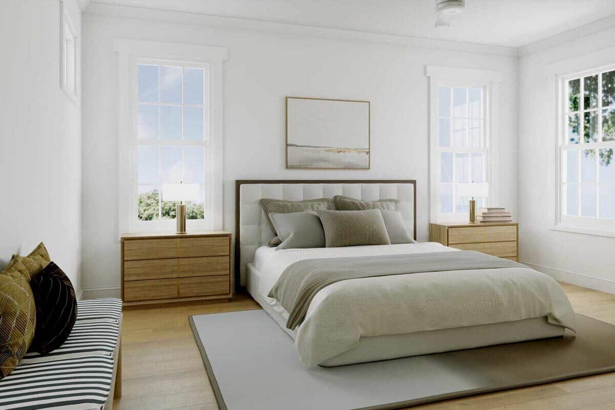 这间卧室里有一张灰色的台床、木制床头柜和一张带抱枕的条纹长凳。