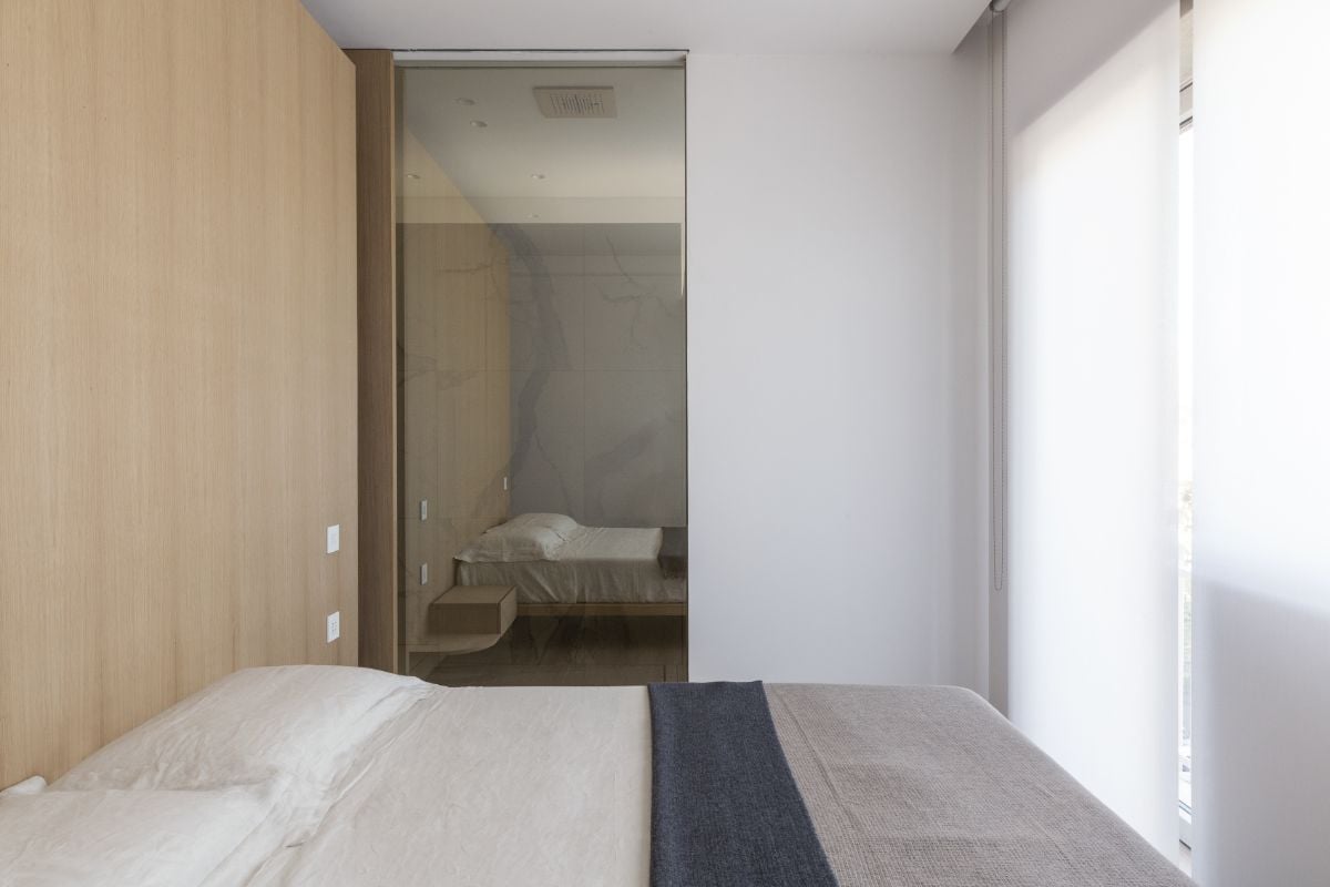 卧室有一个浮动床和磨砂墙,利用白天照明。