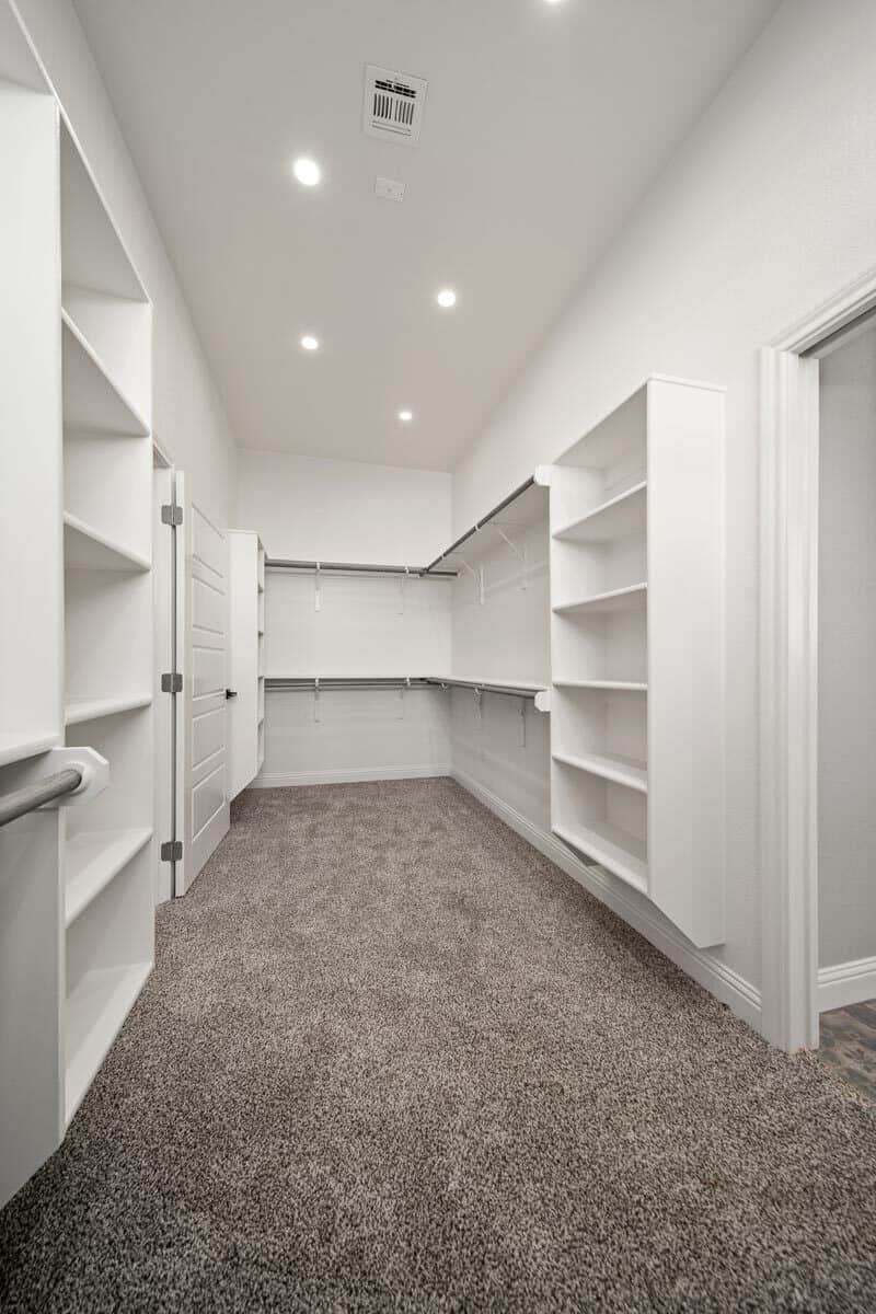 主步入式衣柜，有充足的存储空间和铺着地毯的地板。