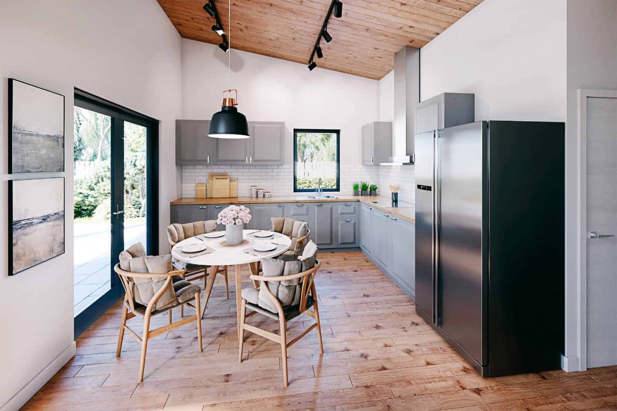 厨房里有灰色的橱柜，木制的台面，棚顶天花板下的圆形餐具。