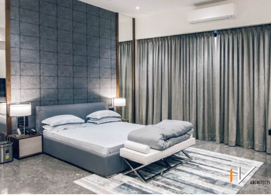 这是一间宽敞的卧室，其设计以灰色为主题，创造出复杂而低调的美学。